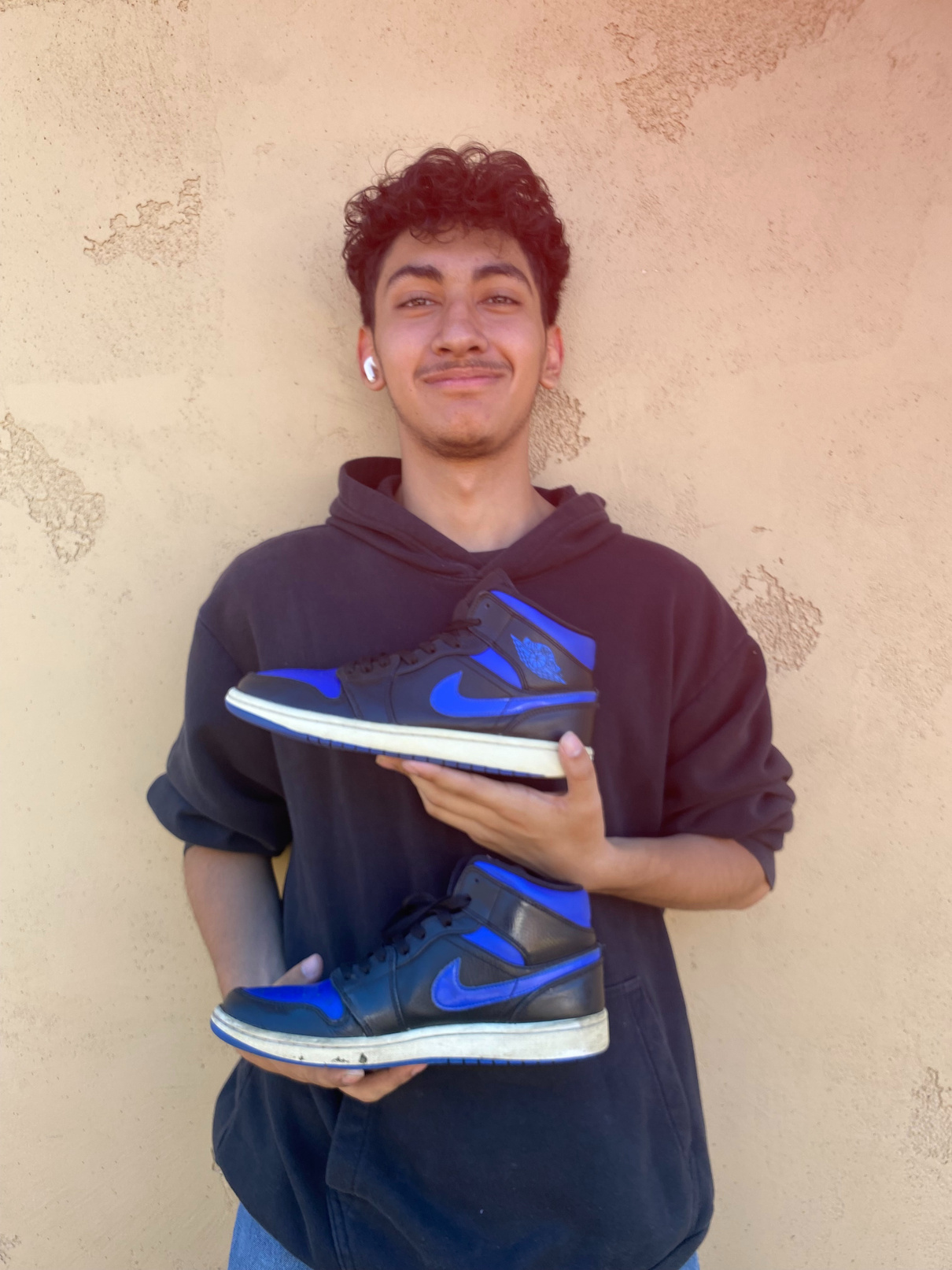 Saul holding a pair of blue and black Jordan sneakers